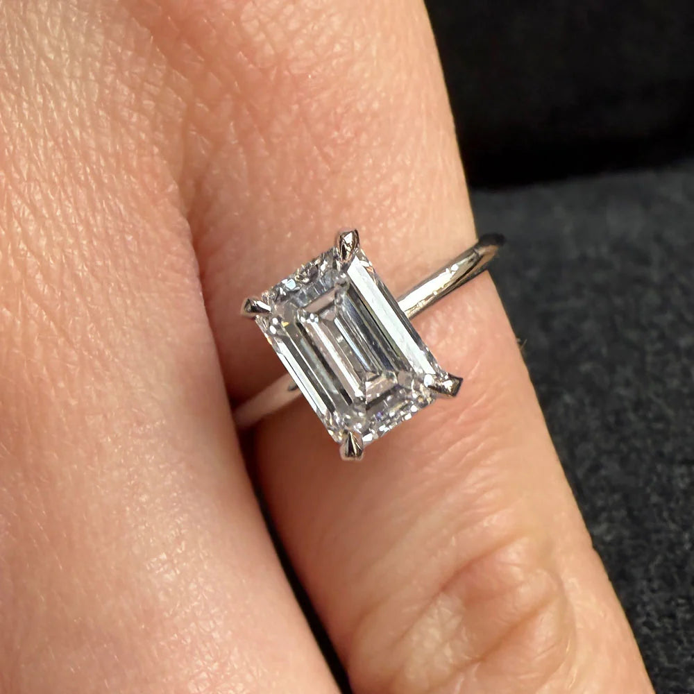 Diamond ring on a finger with a blurred background